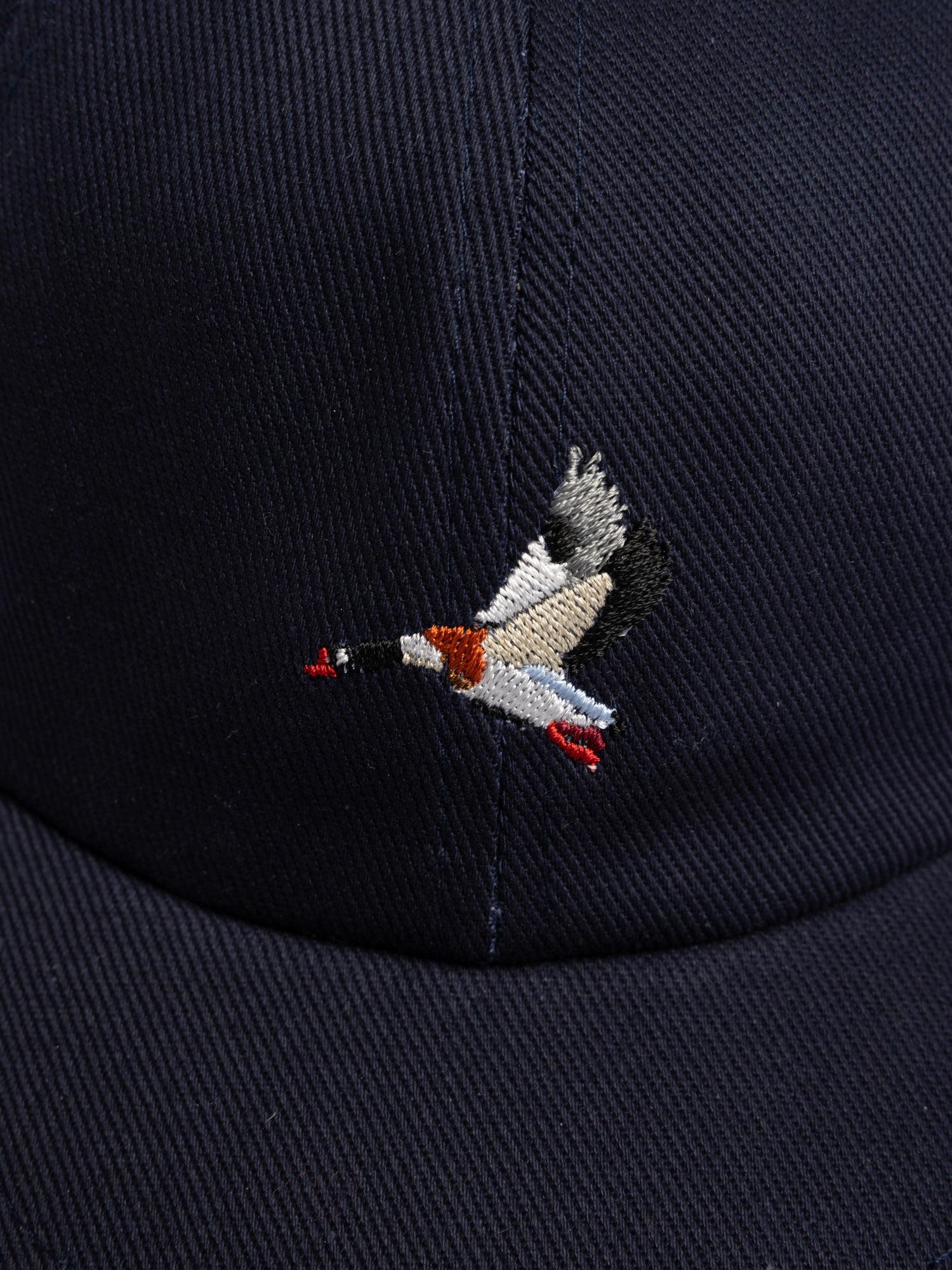 Embroidered duck design on a navy blue cap