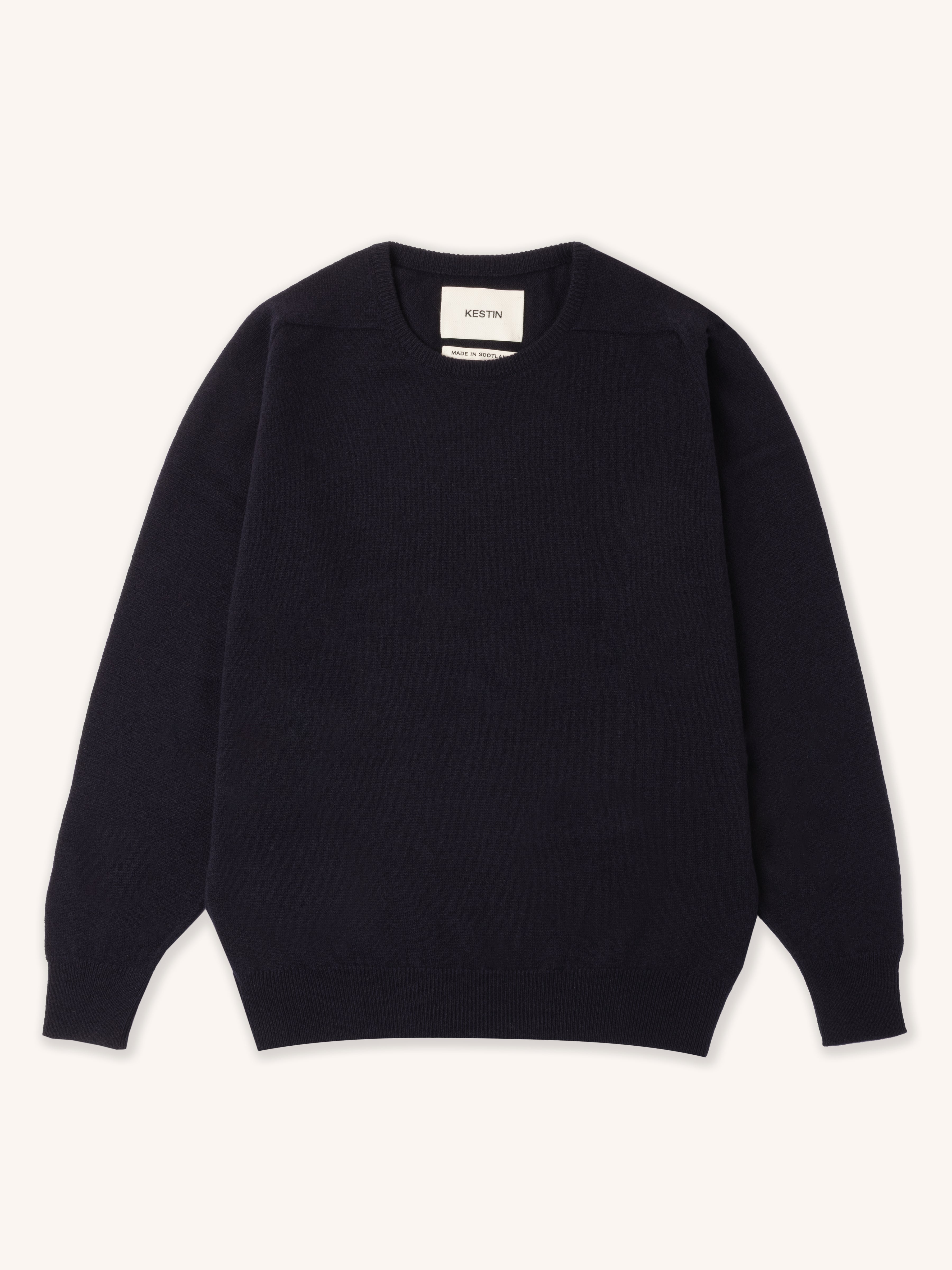 A navy blue knitted sweater, on a white background.
