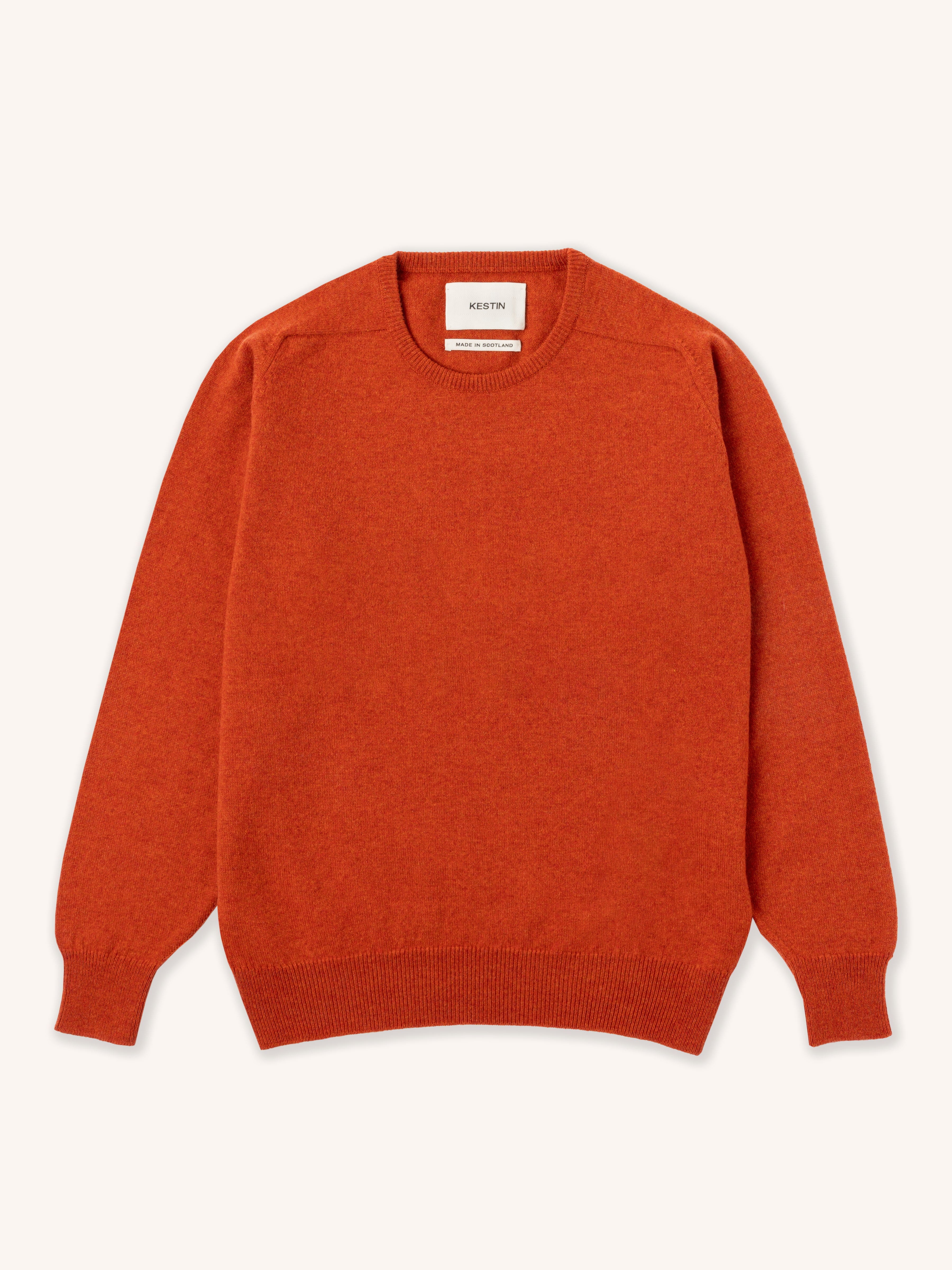 Orange lambswool sweater on a white background