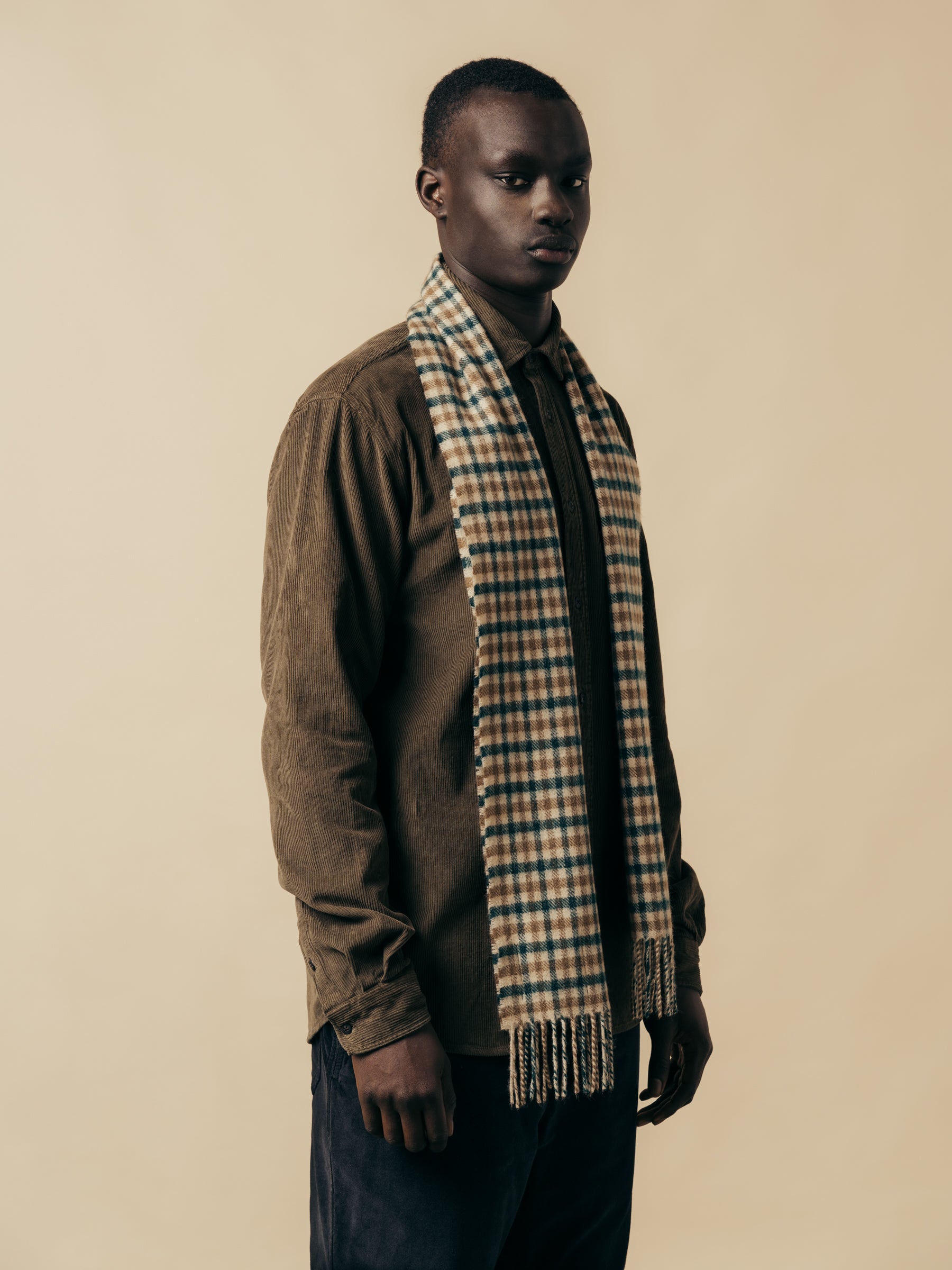 A model wearing a green and brown check lambswool scarf