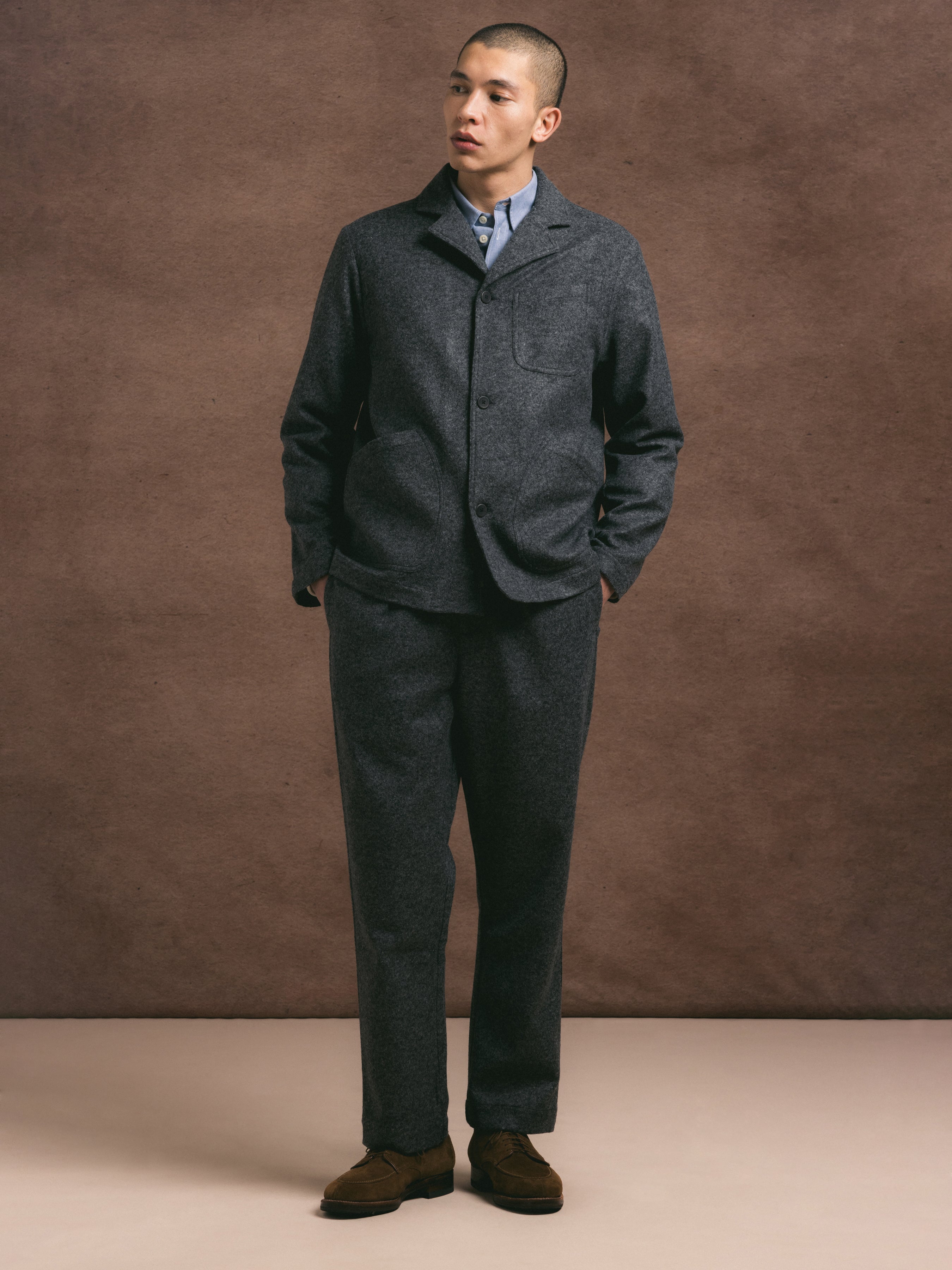 A model wearing a charcoal two piece suit in a premium wool blend fabric