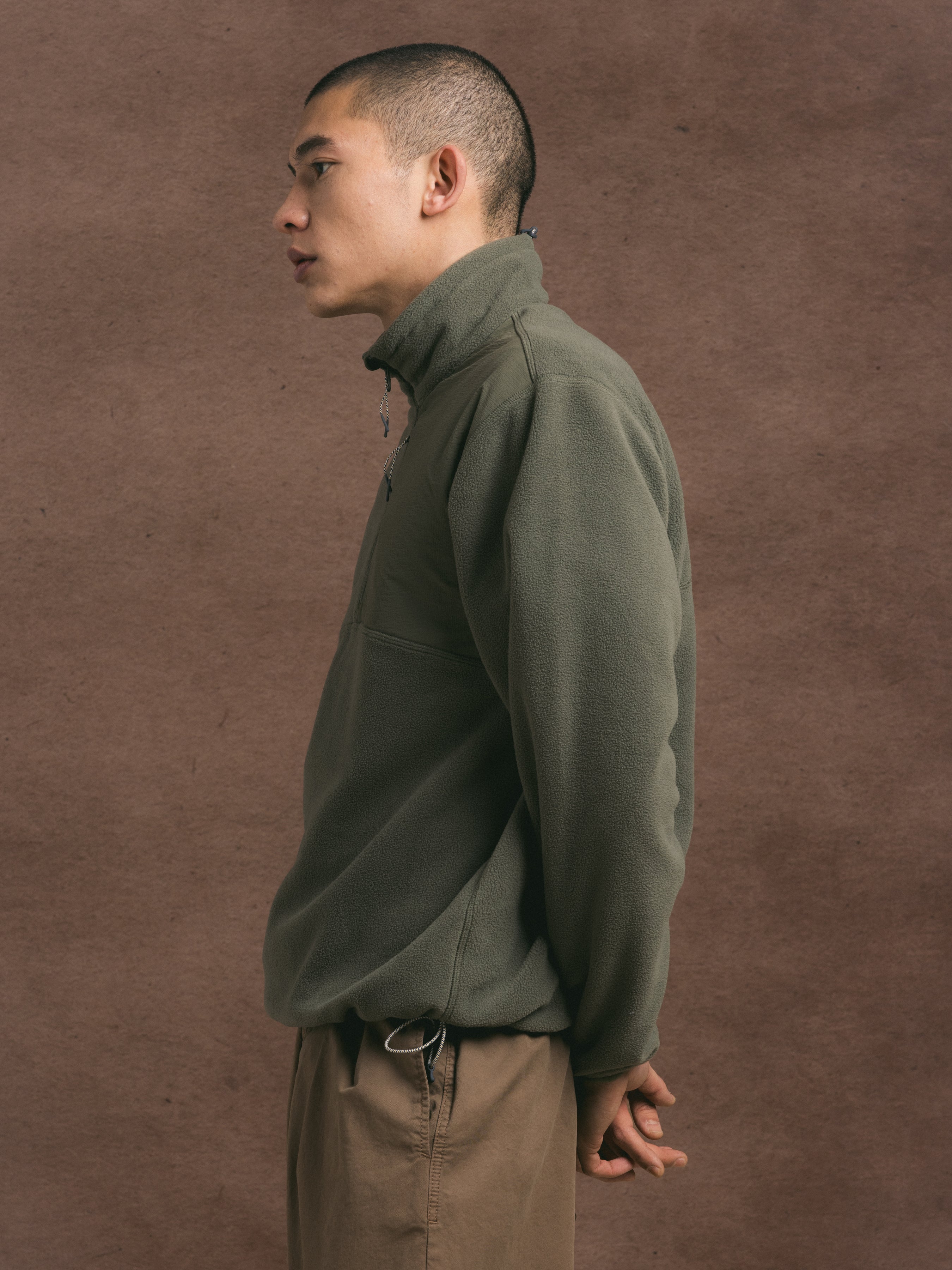 side profile of a man wearing a green fleece from menswear brand KESTIN