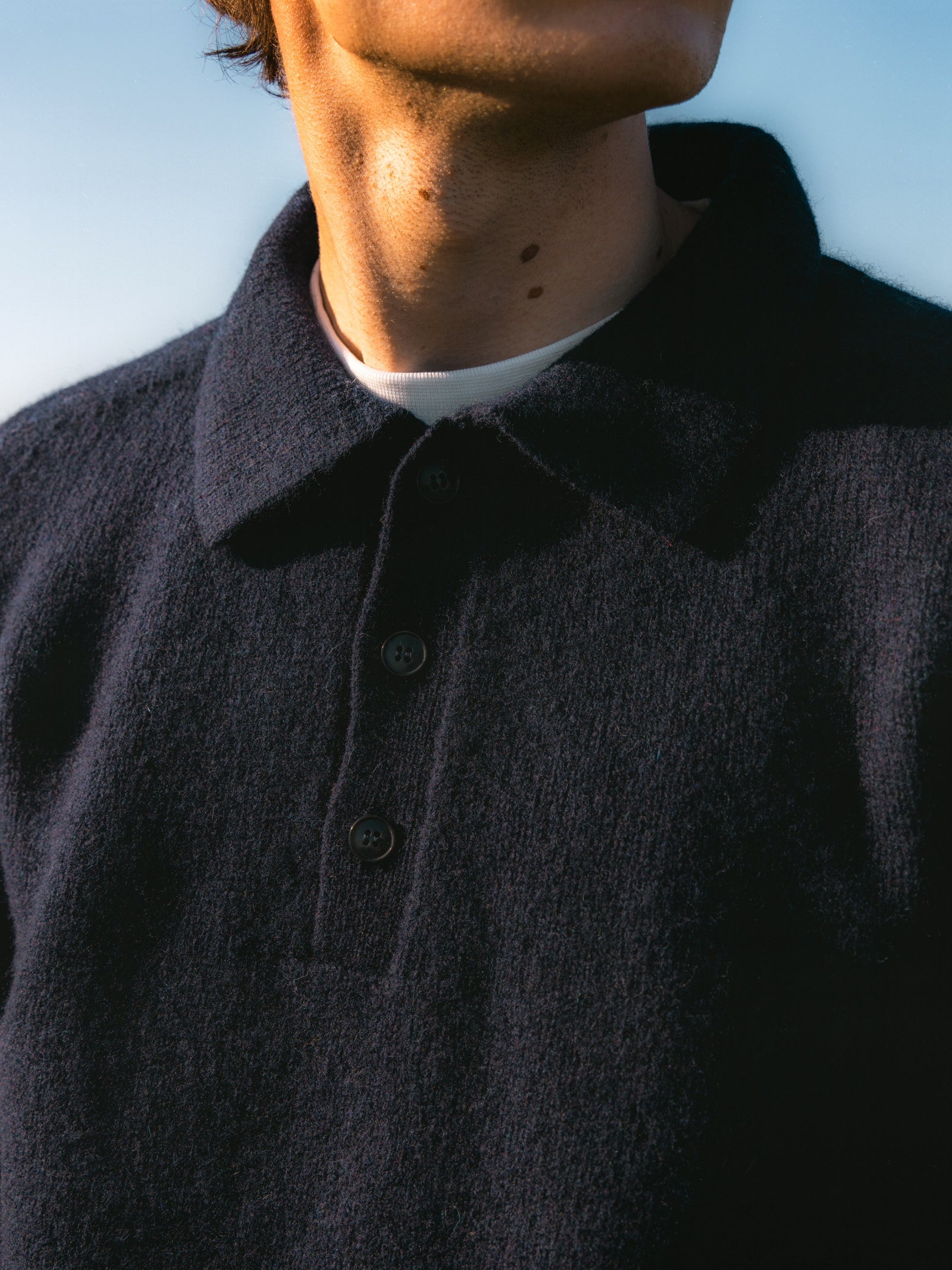 A close-up of the Lewis Shetland Polo's collar, worn on a model.