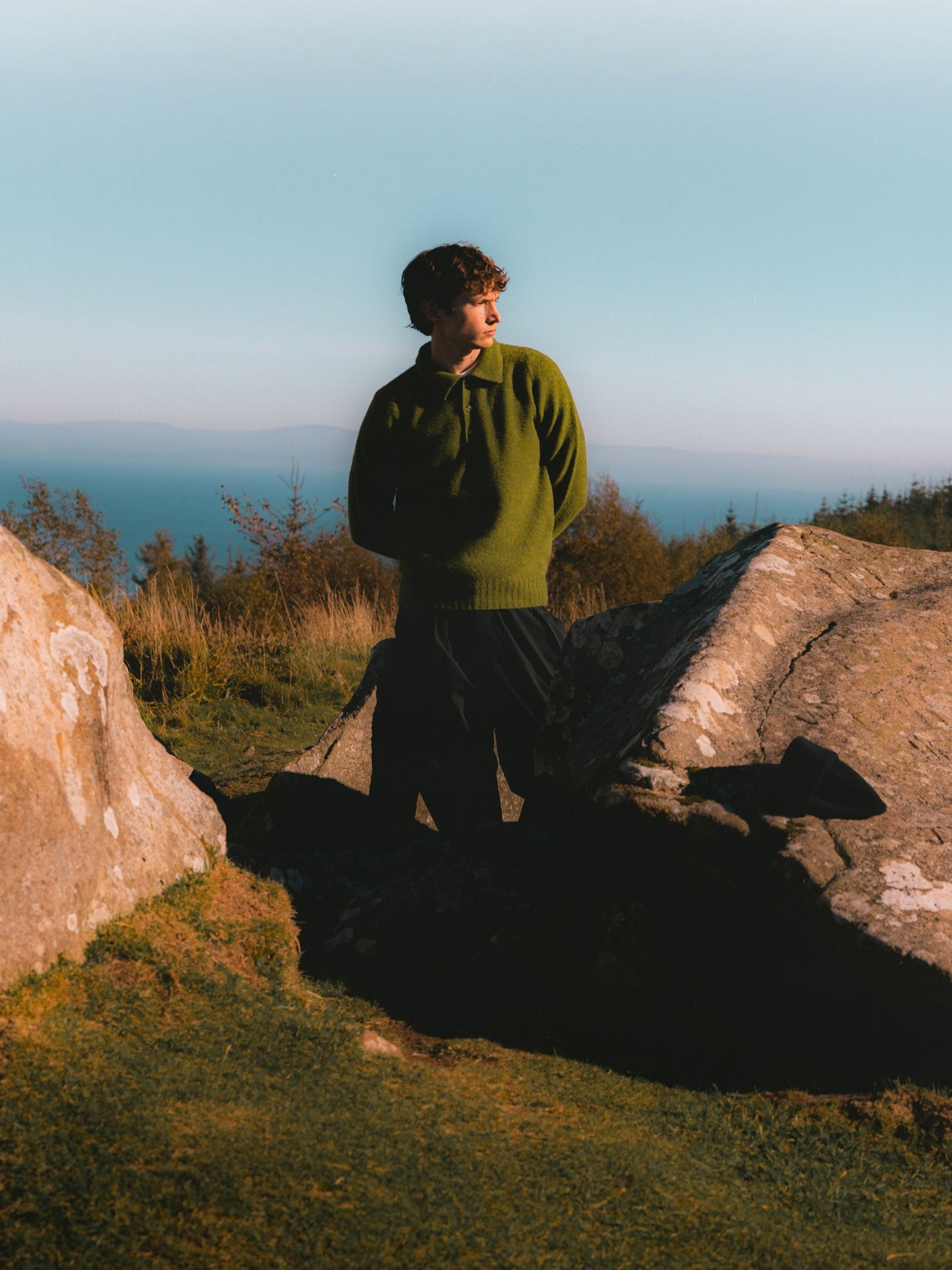 A man standing on the Isle of Arran, wearing made in Scotland knitwear.