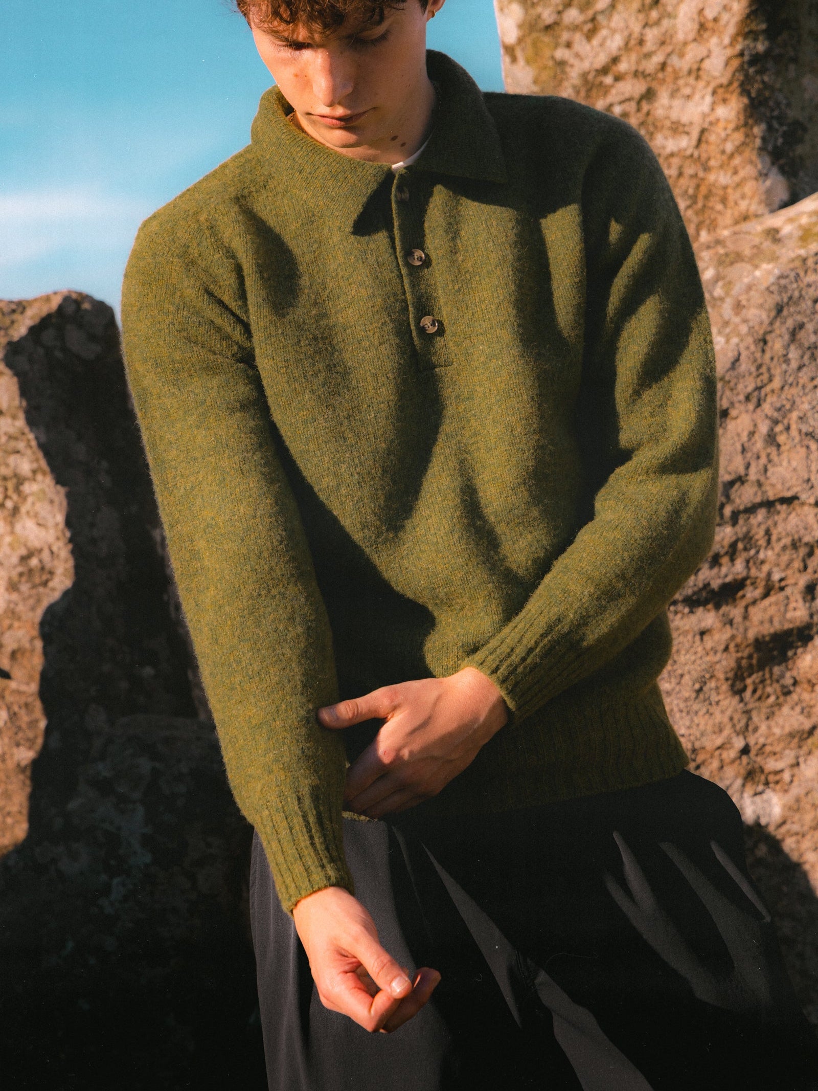 A model adjusting the cuff of the KESTIN Lewis Shetland Wool Polo Sweater.