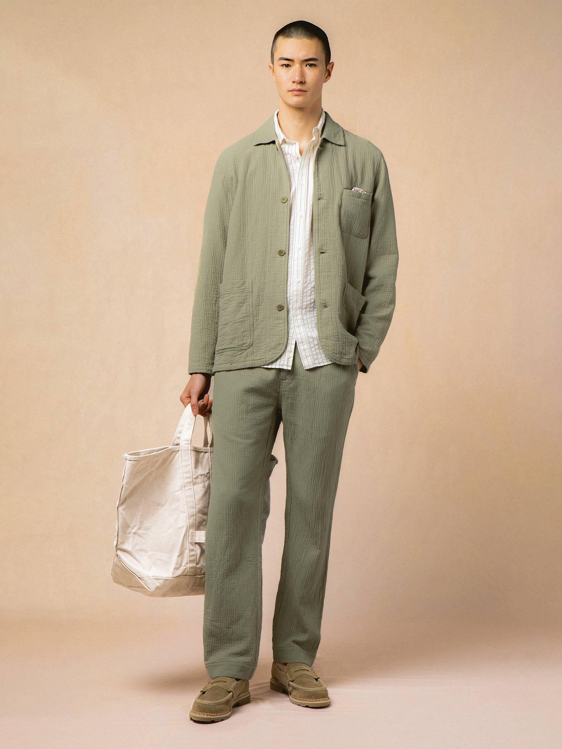 A model wearing a simple, casual cotton workwear suit.
