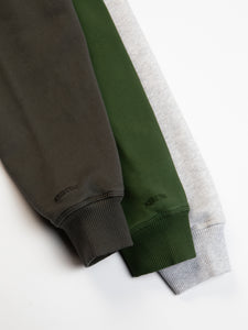 Three cuffs from the KESTIN St Andrews Hoodie, in grey, charcoal and green.