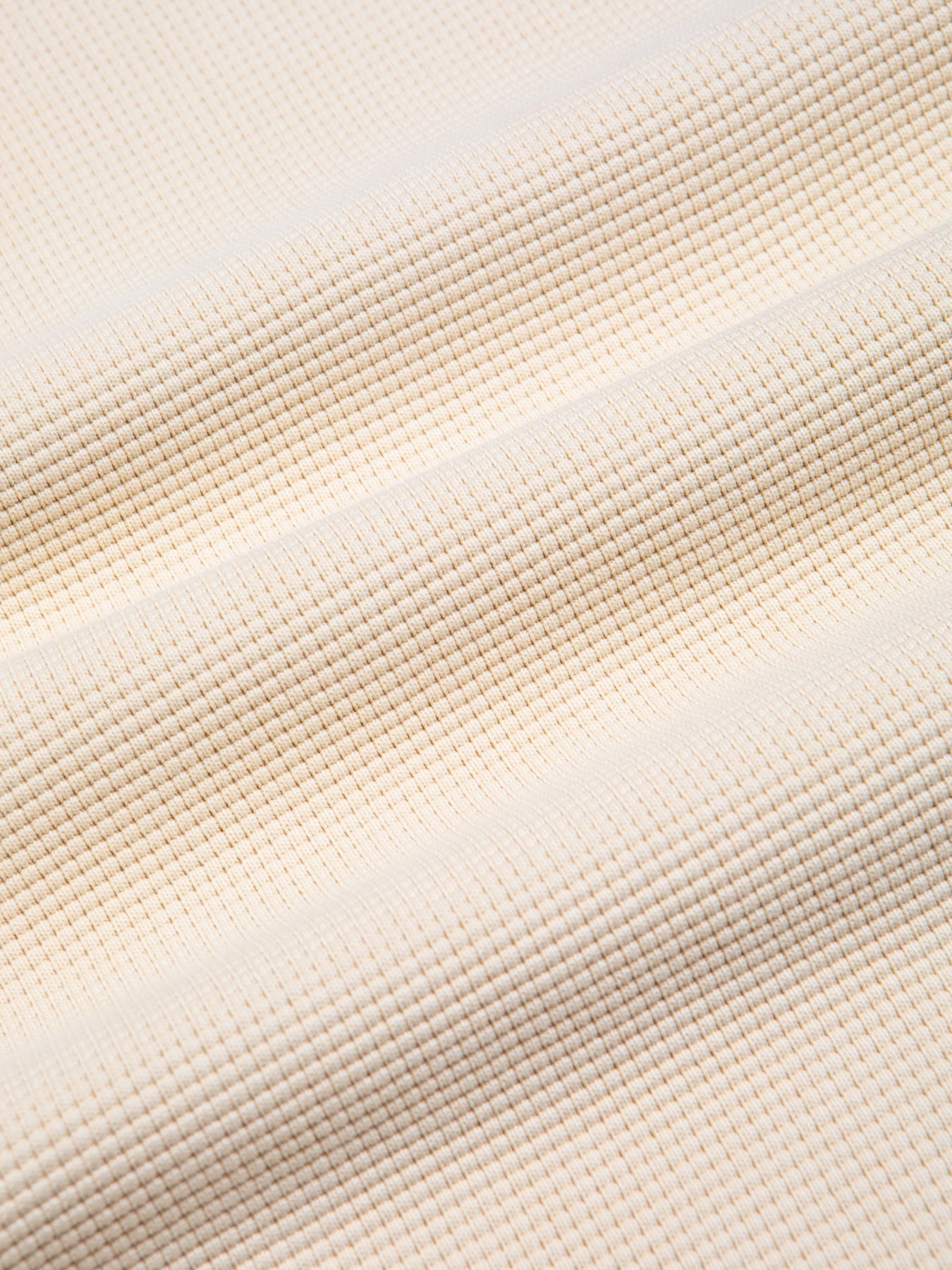 A close-up of a natural colour waffle knit fabric, made from 100% cotton.