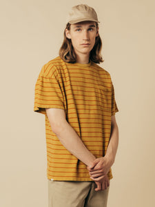 A model wearing the KESTIN Fly Tee in a yellow stripe colour.
