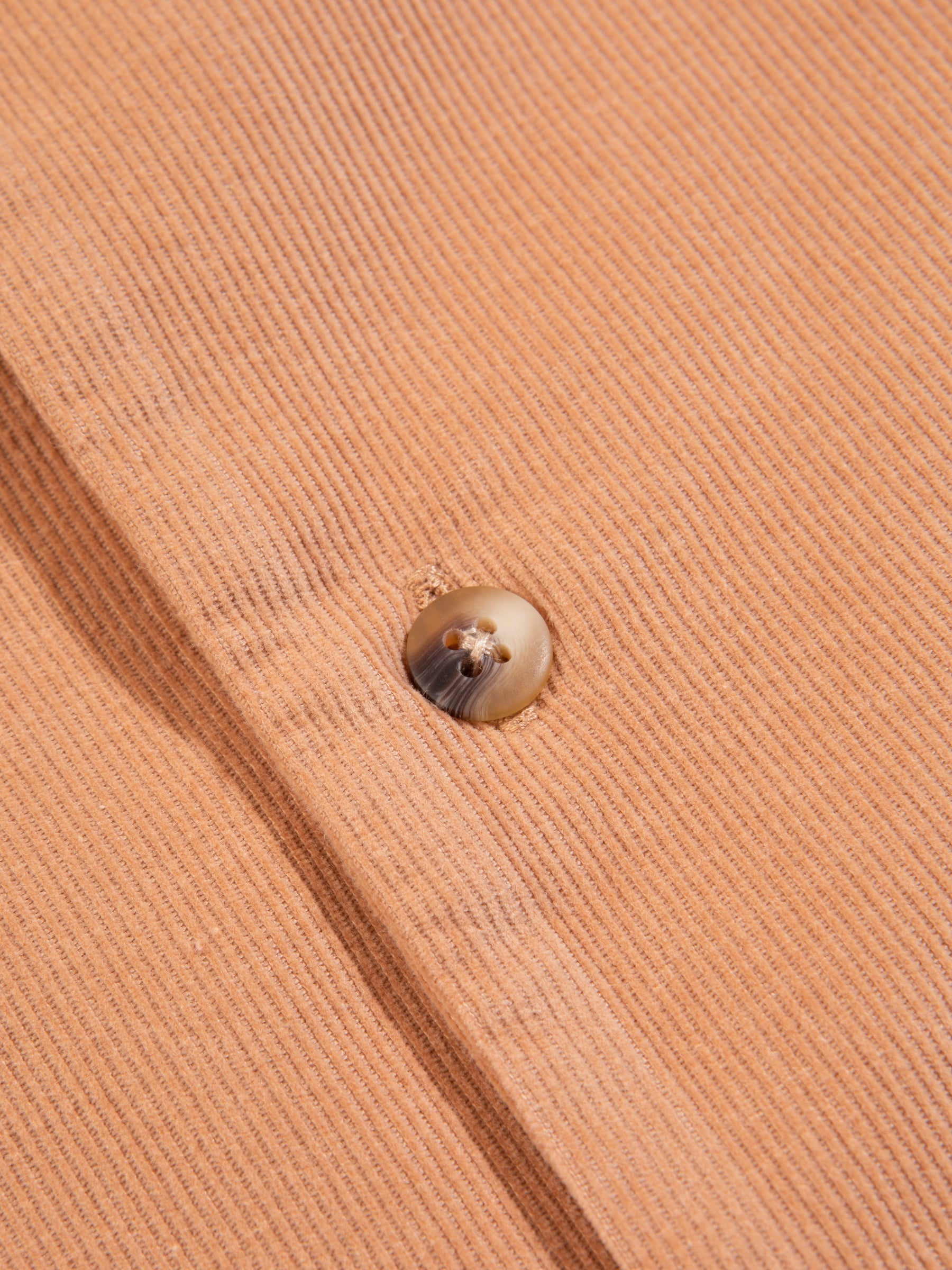 A close-up of the button on the KESTIN Tain Shirt in Organic Corduroy.