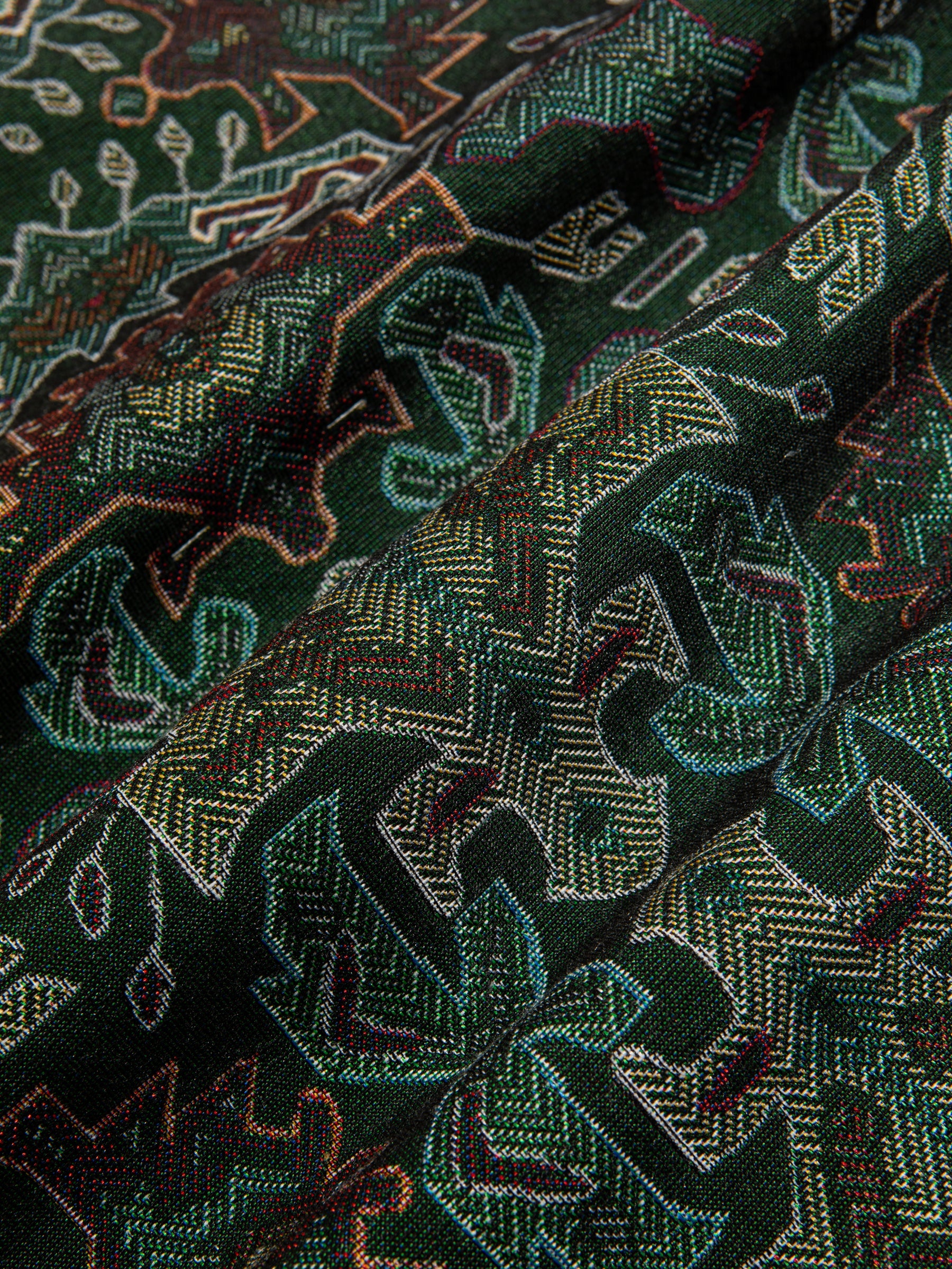 A close-up of a dark olive green Ikat jacquard fabric, from menswear brand KESTIN.