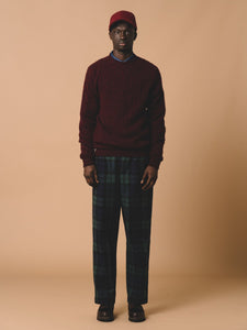 A man wearing the KESTIN Galloway Cable Knit Sweater in Maroon Red.