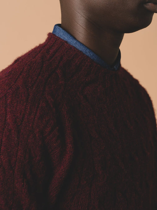 The ribbed collar to the KESTIN Galloway Cable Knit Sweater in Maroon Red.