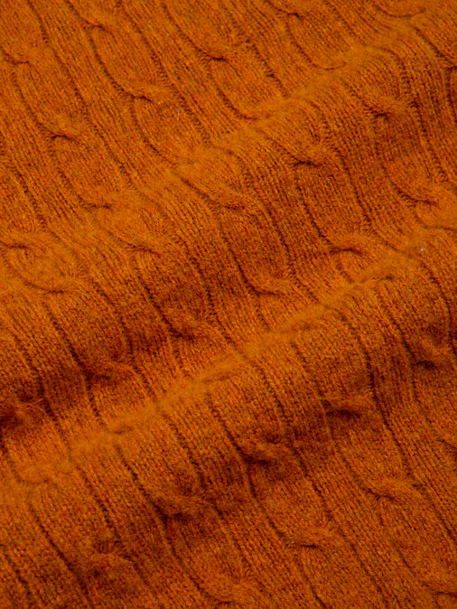 A cable knit fabric made from brushed shetland wool, dyed in tangerine orange.