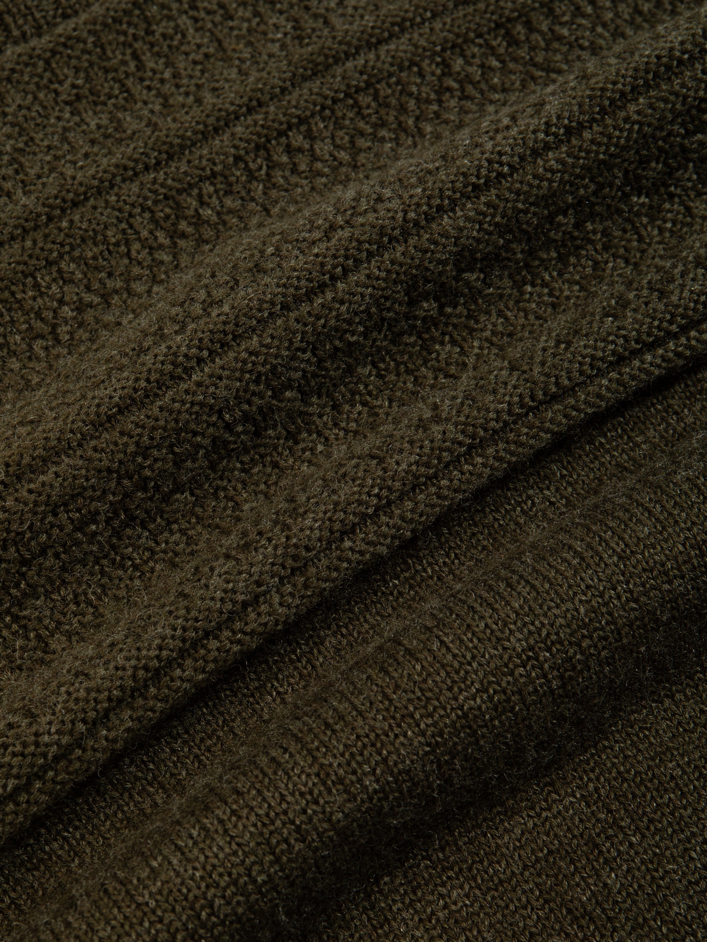 A knitted merino wool material, made in Scotland in olive green.