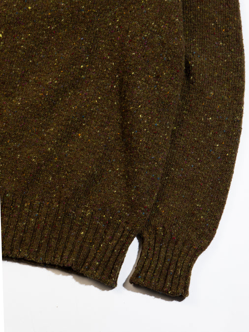 A Donegal wool sweater in olive green with a ribbed hem and cuff.