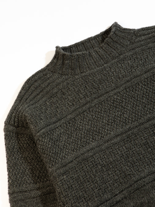 A men's knitted sweater, made in Scotland from merino wool in charcoal grey.