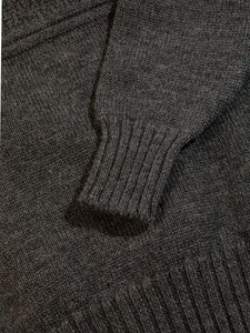 The ribbed hem and cuff from a men's knitted sweater in charcoal grey.