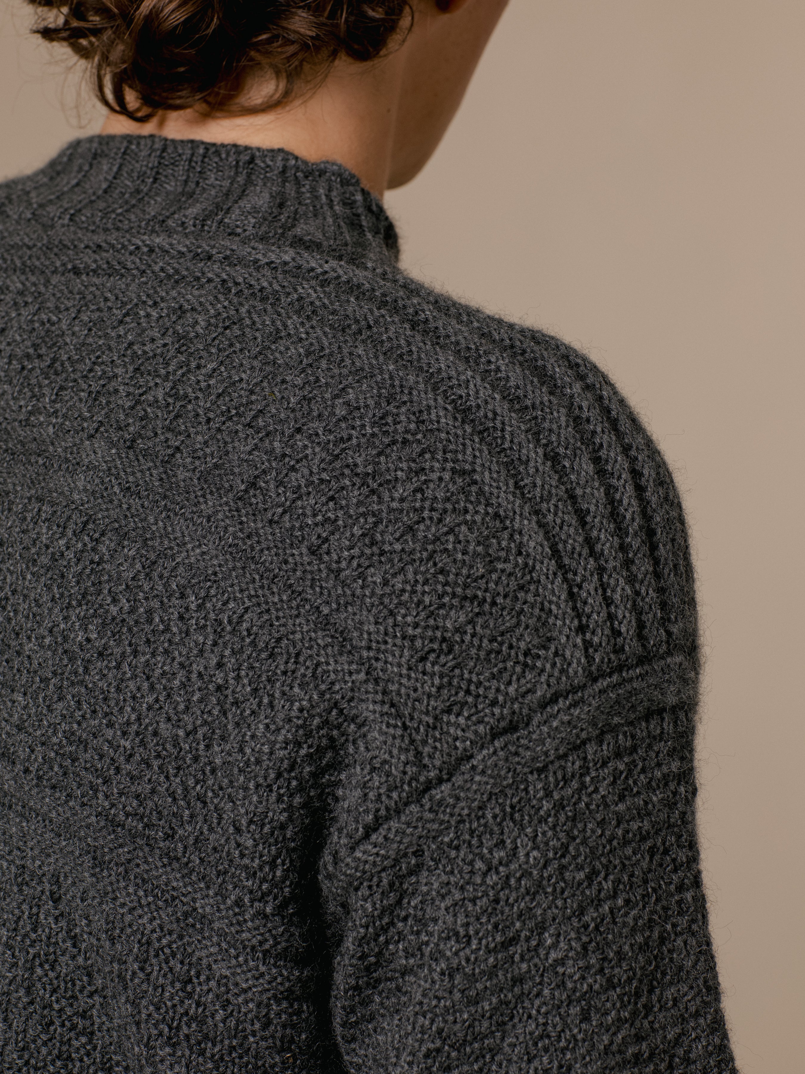 The saddle shoulder of the KESTIN Fife Gansey sweater in charcoal grey.