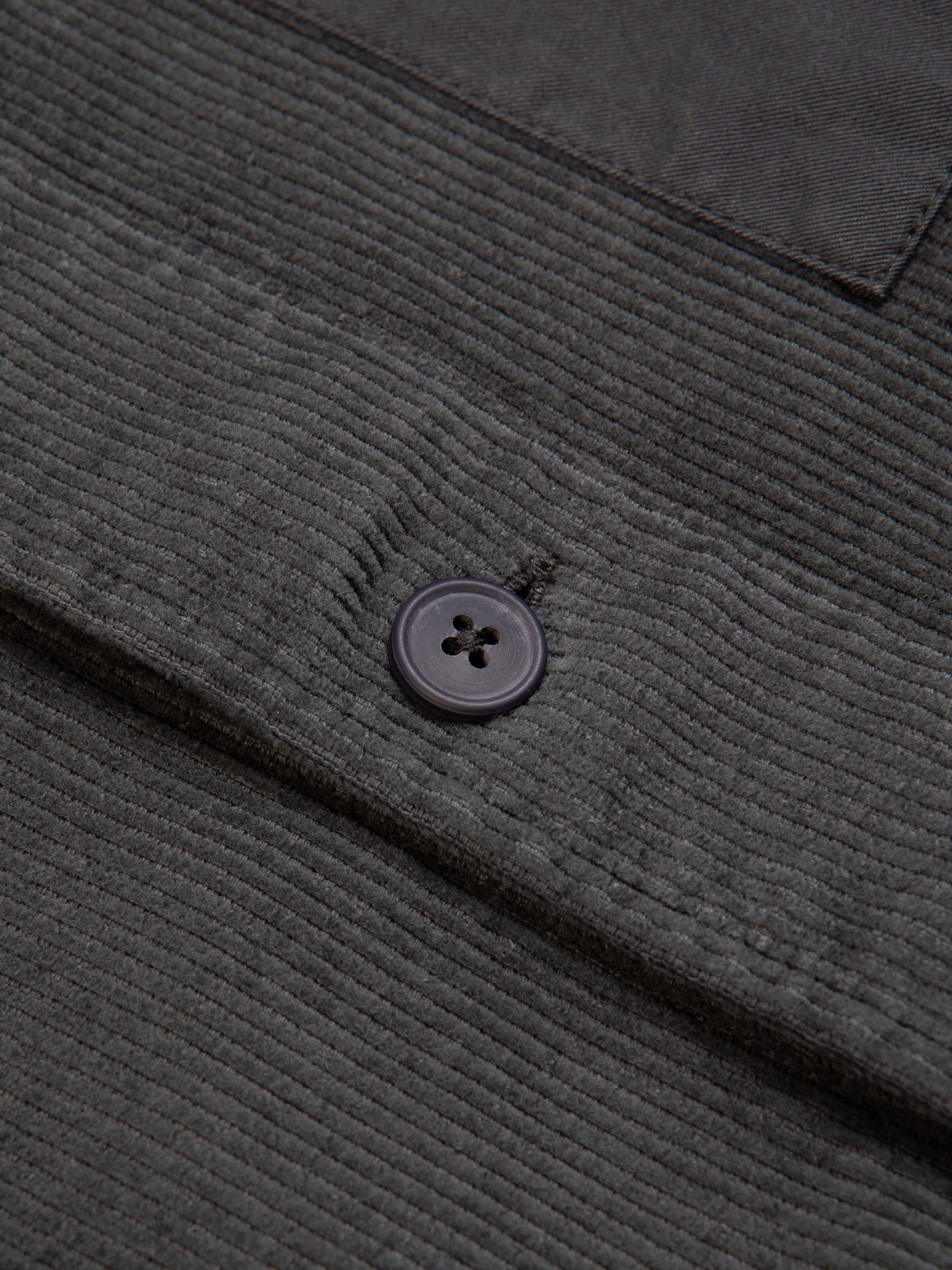 The button to the front of an overshirt from menswear designer KESTIN