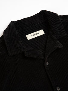 The open collar of the Tain Overshirt in Black Corduroy from menswear brand KESTIN.