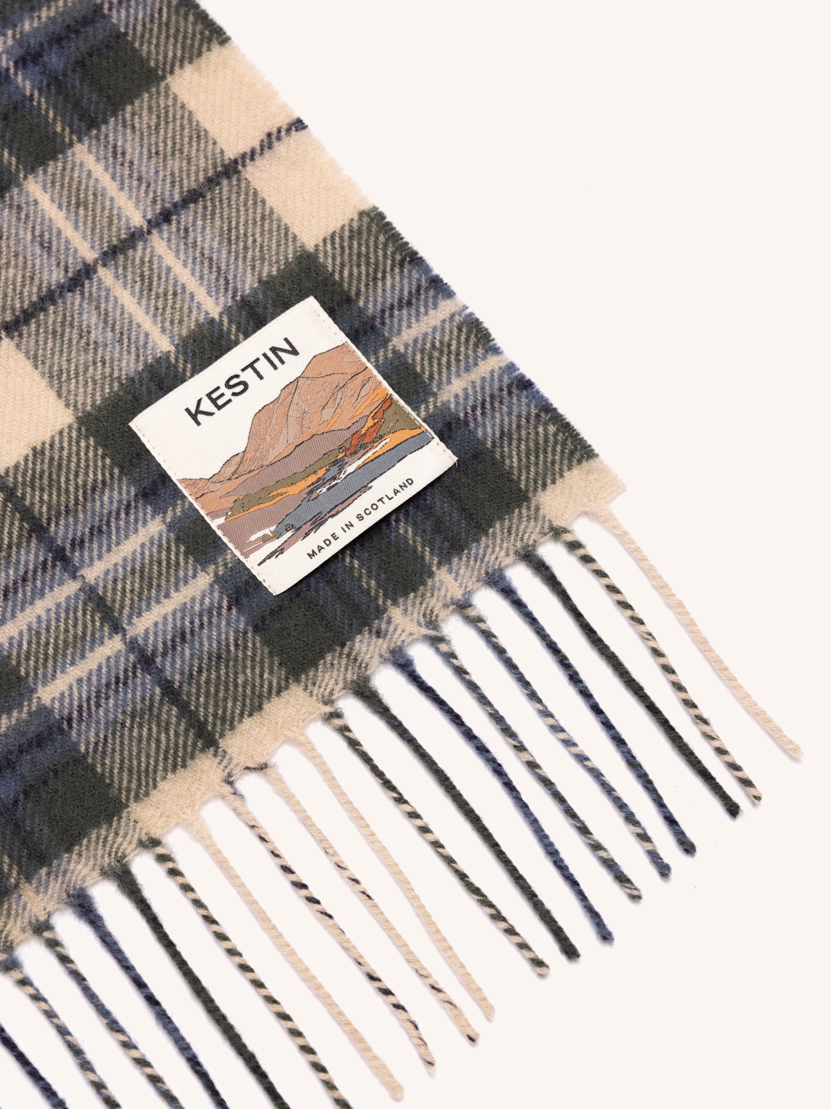 Plaid scarf with fringes and Kestin label on a white background