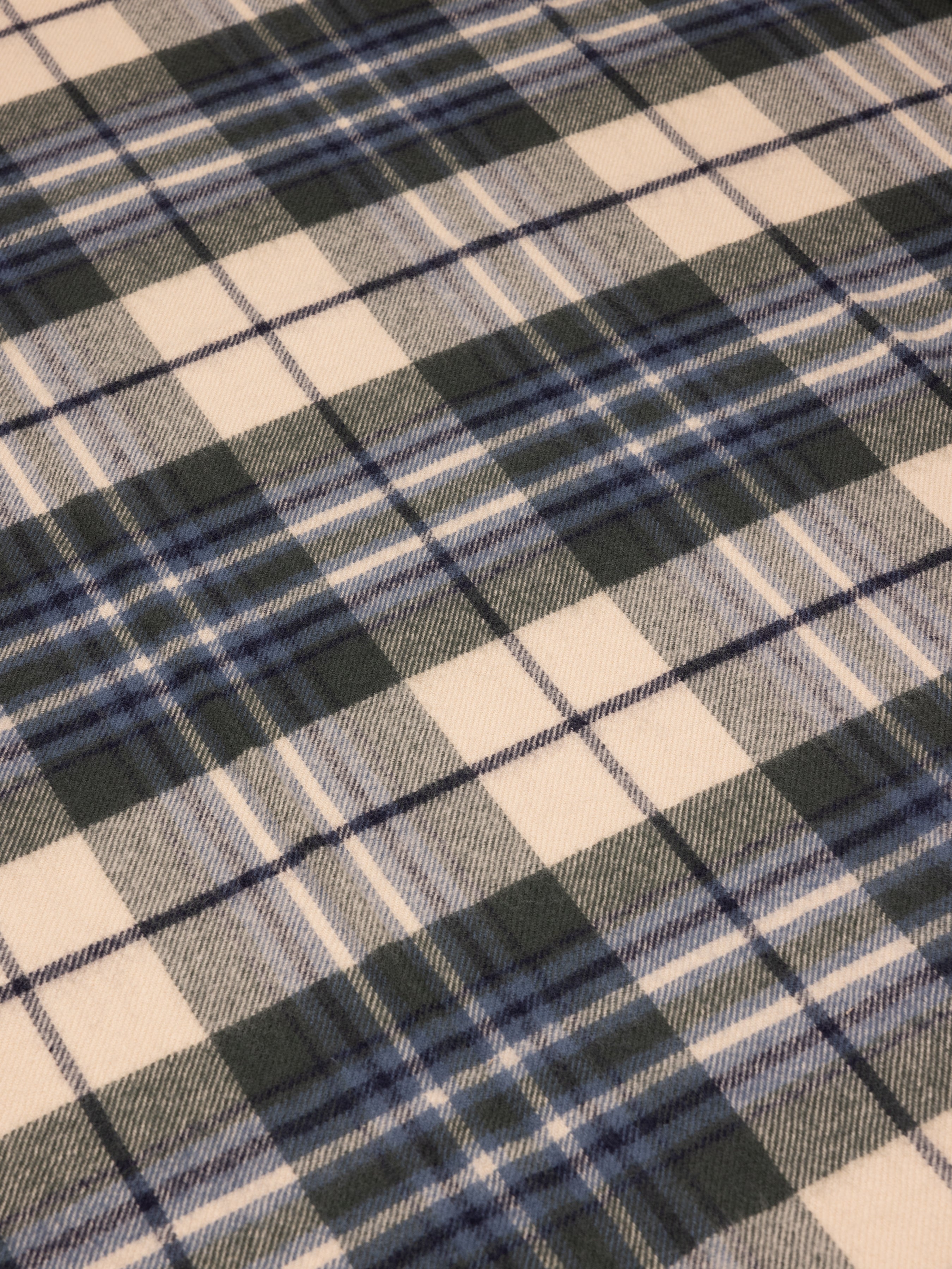 Close-up of a plaid fabric with blue, gray, and beige colors.
