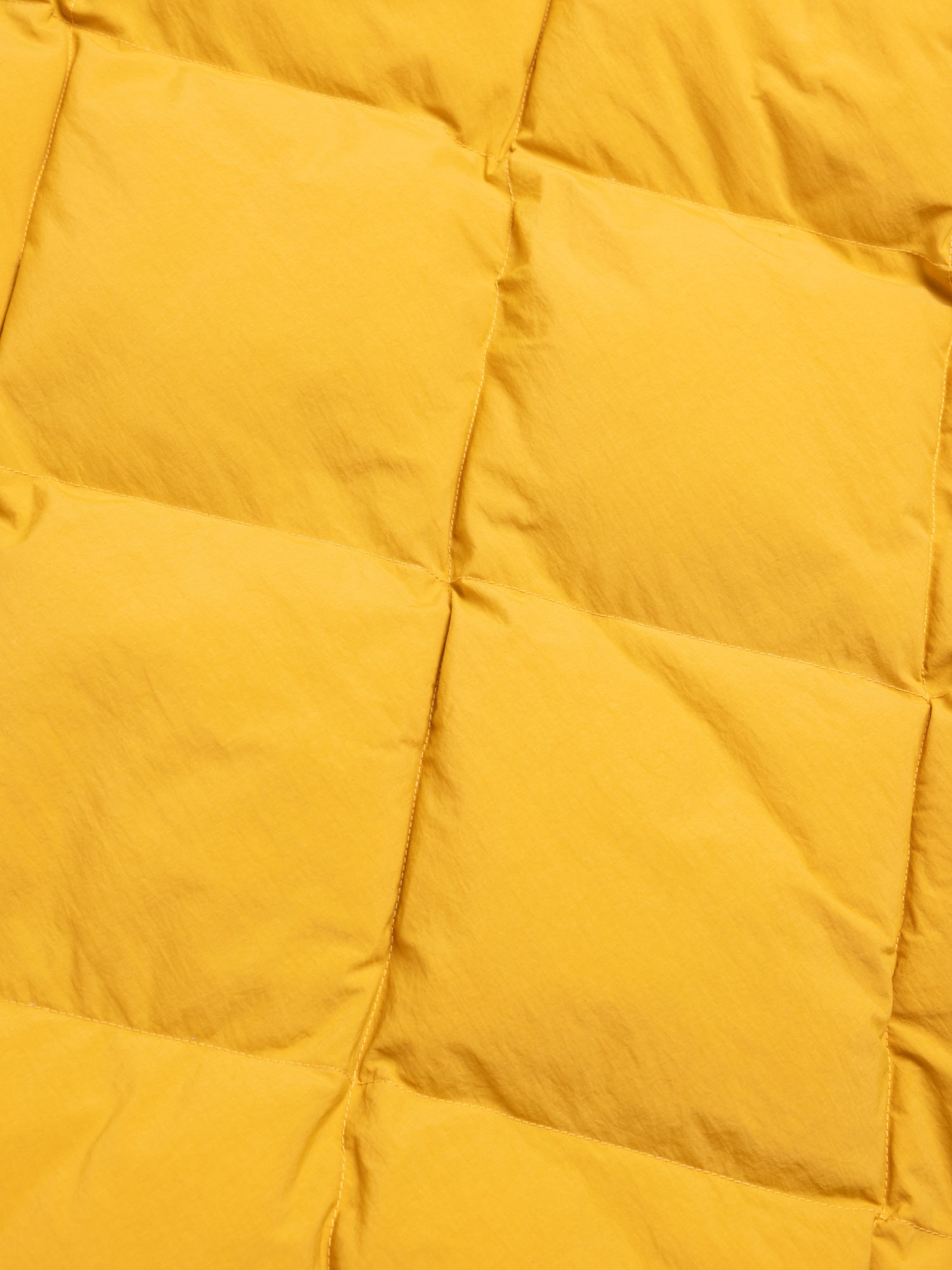 Close-up of a yellow quilted fabric surface