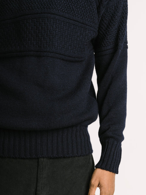 A man showing the sleeve and cuff fit of the Fife Gansey Merino Wool Sweater by KESTIN.