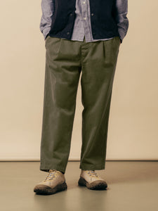 A model wearing olive green trousers with a blue shirt and trail shoes.