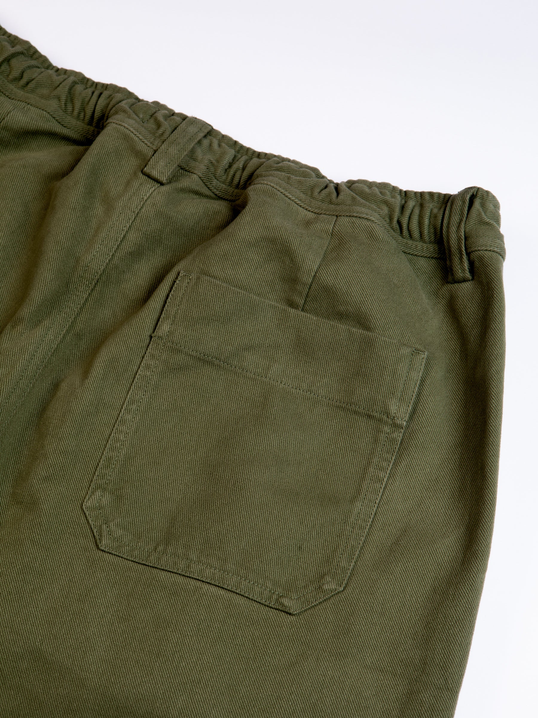 The rear pocket of the Doune Pant by KESTIN, in an olive green twill.