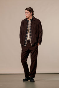 An autumn layered men's outfit, with dark brown corduroy and a flannel shirt.