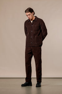 A model wearing the KESTIN Huntly Suit, in a dark brown waffle-corduroy material.