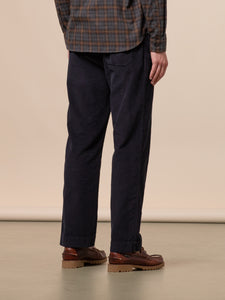 A pair of navy blue corduroy trousers, worn with brown Sebago shoes and a flannel shirt.