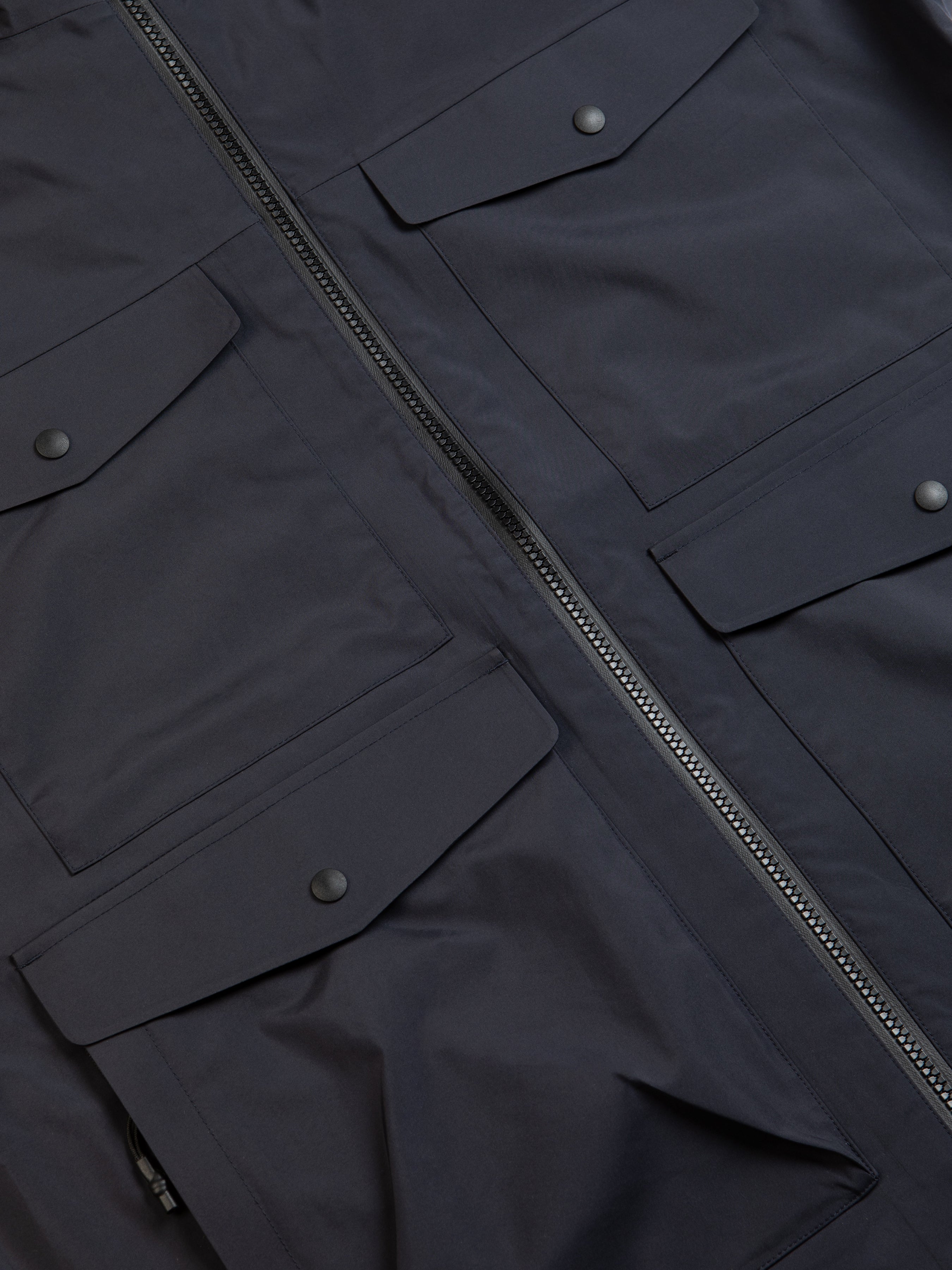 A navy blue waterproof jacket with four patch pockets to the front.