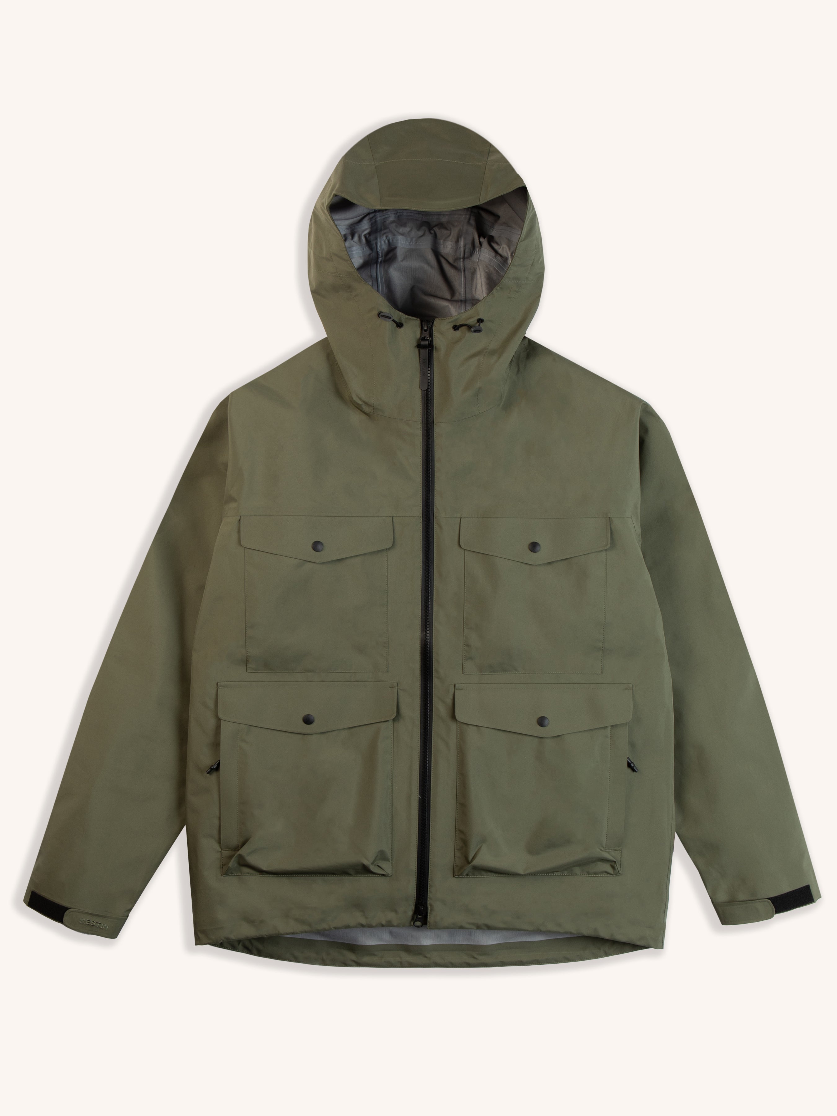 A technical waterproof shell jacket in green on a white background.