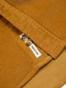 A warm yellow moleskin shirt, with a woven logo patch to the hem.