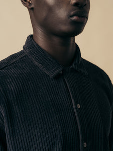 A black corduroy overshirt worn on a model.