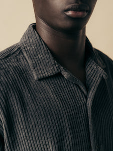 A shirt with an open collar, made from a charcoal grey corduroy fabric.