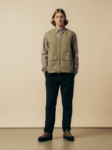 A man wearing black corduroy trousers and a green shirt from KESTIN.