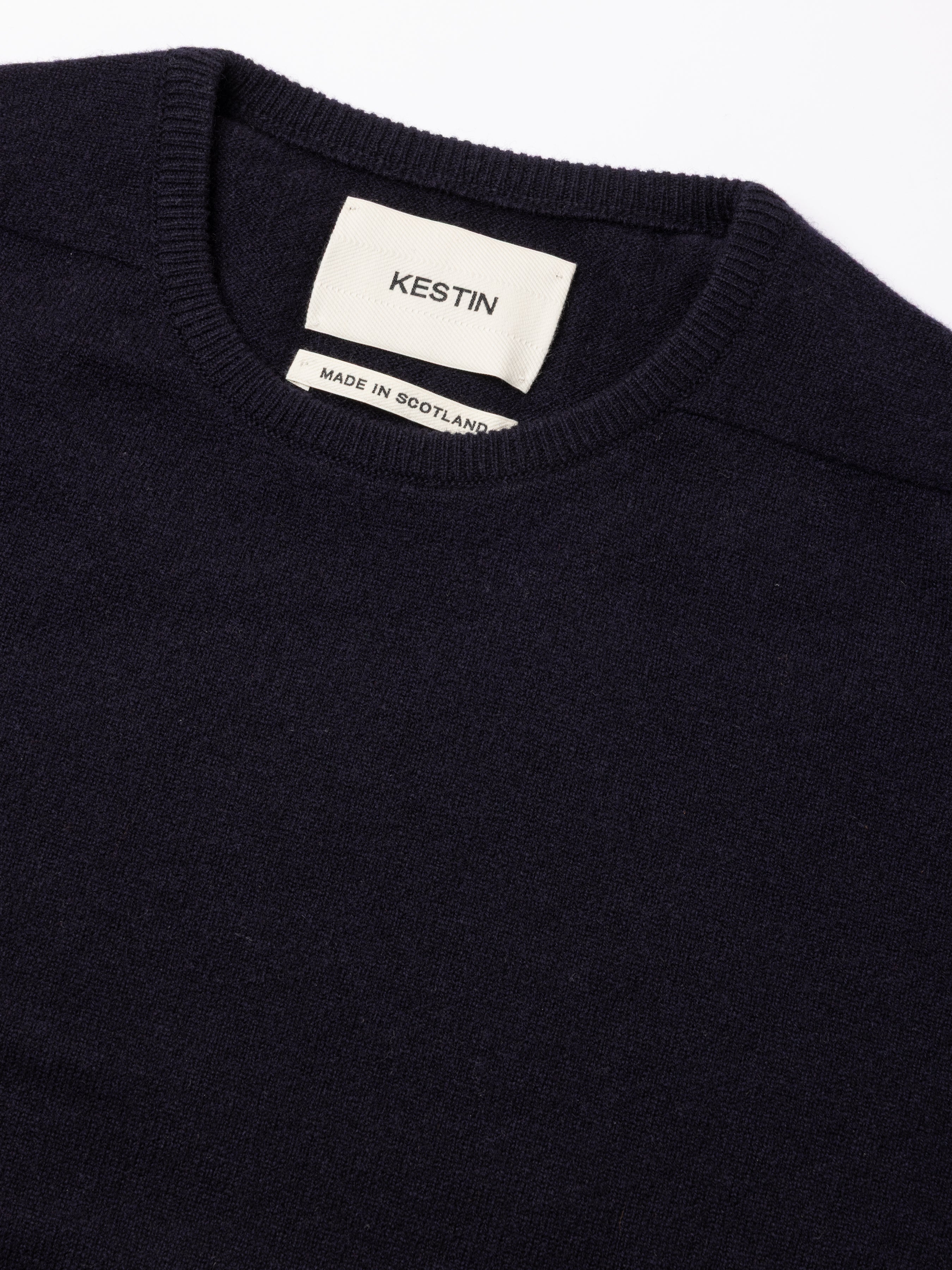 Navy sweater with a visible KESTIN Made In Scotland label on a white background