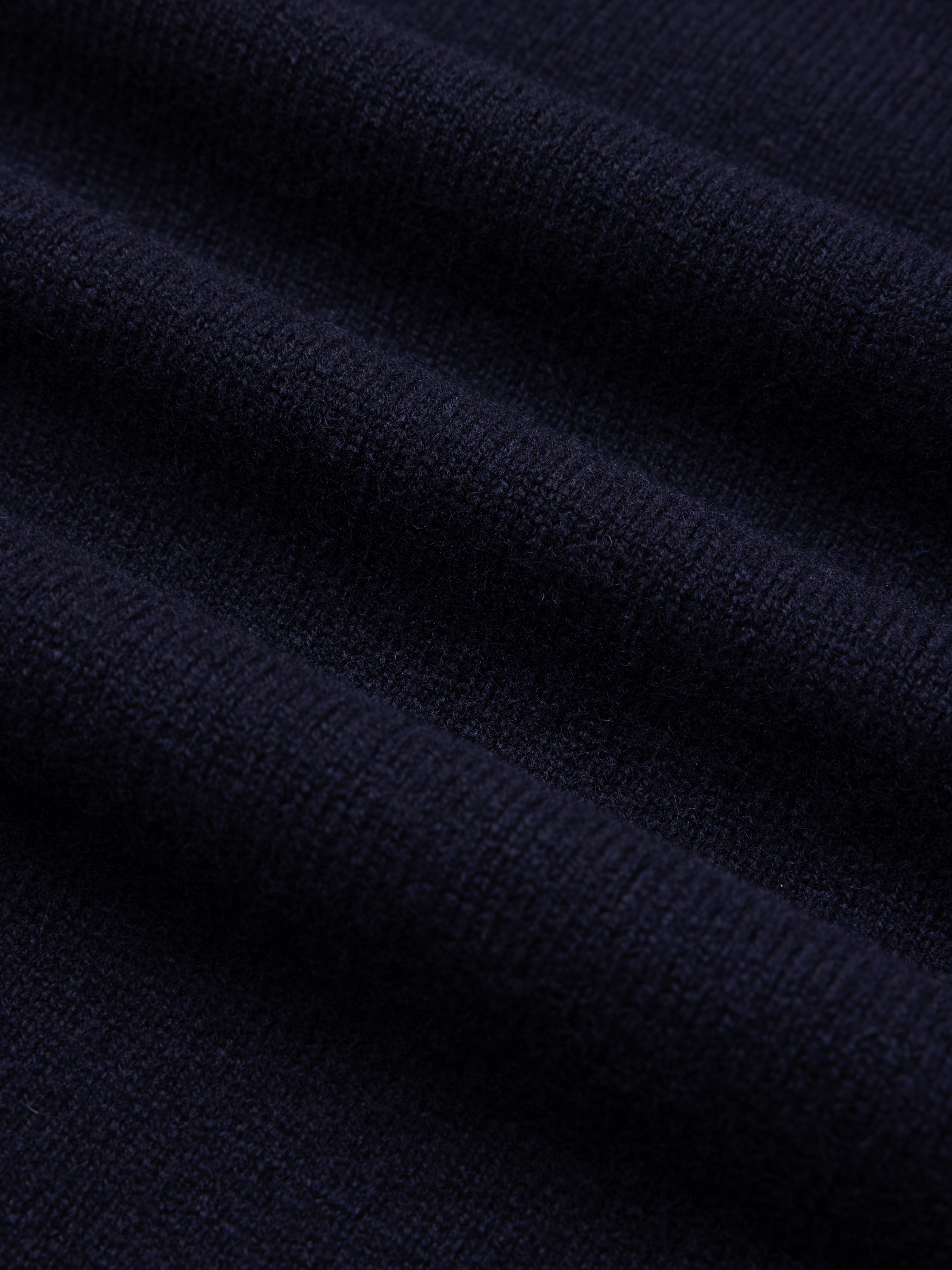 Close-up of a dark navy blue lambswool sweater.