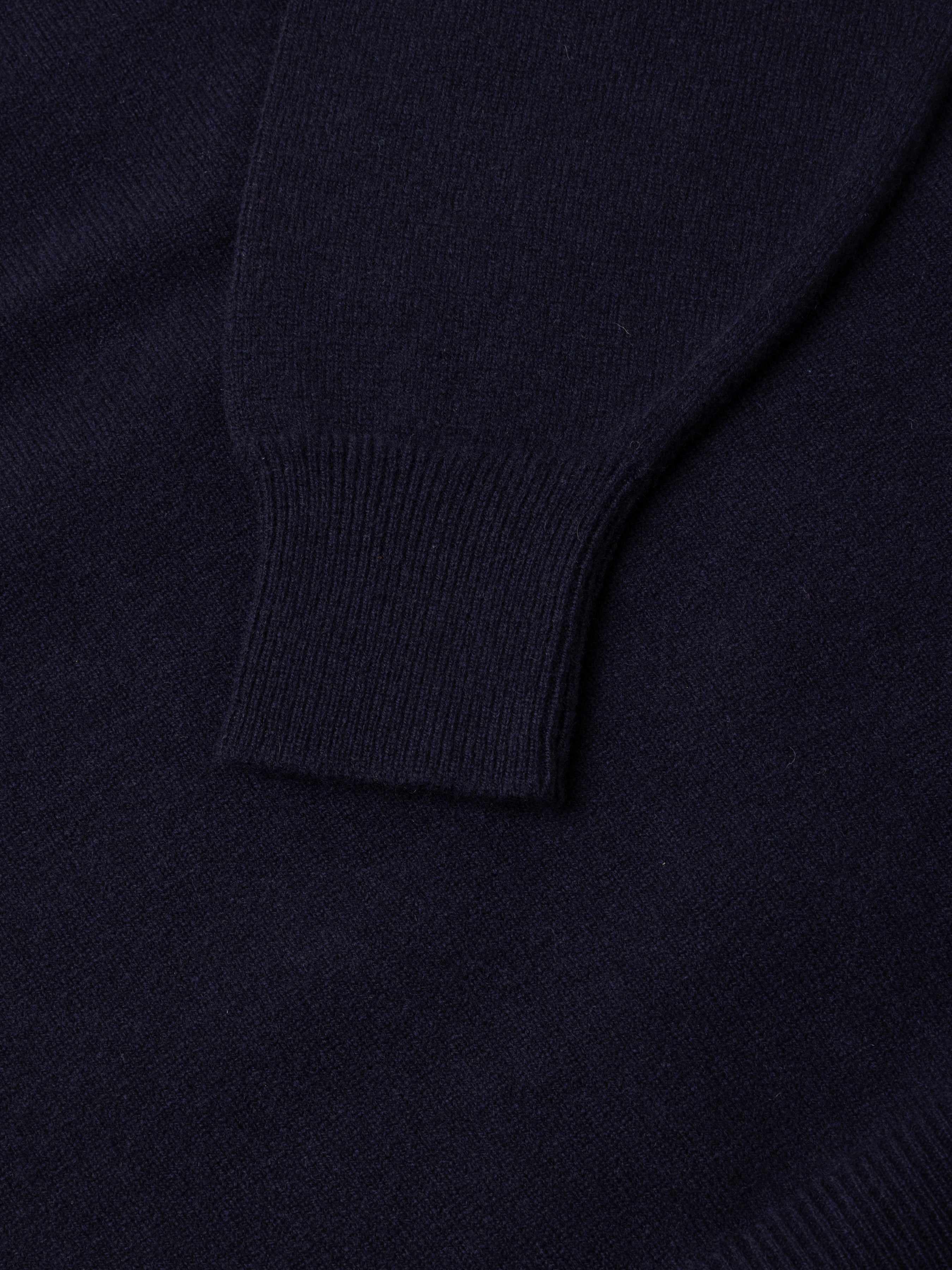 Close-up of a dark blue sweater sleeve and fabric texture