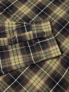Close-up of a plaid shirt with brown, green, and black colors.