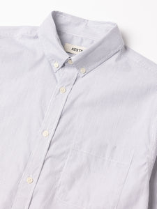 Close-up of a light blue striped shirt with a collar, featuring a KESTIN label