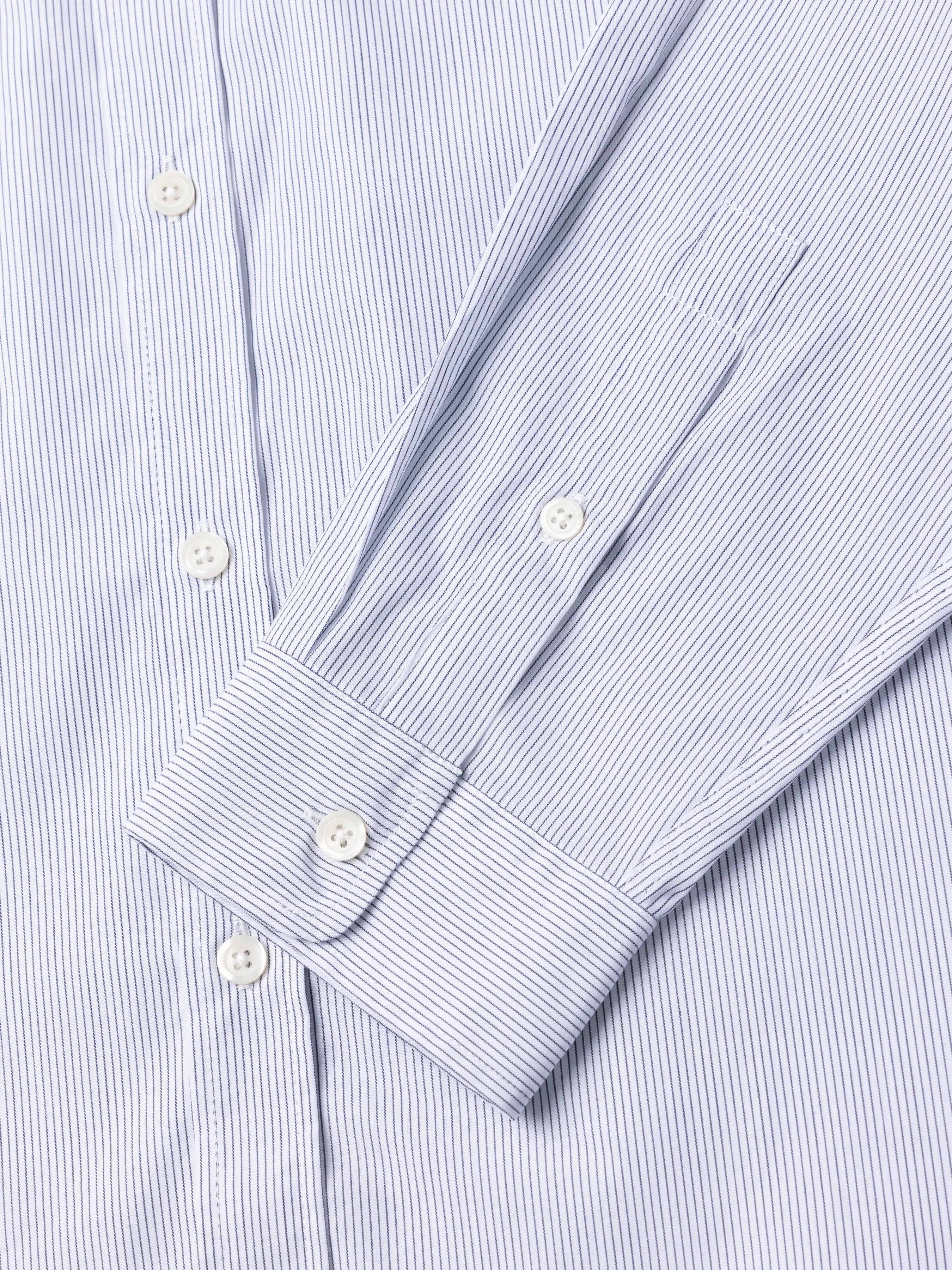 Close-up of the cuff of a blue and white striped shirt