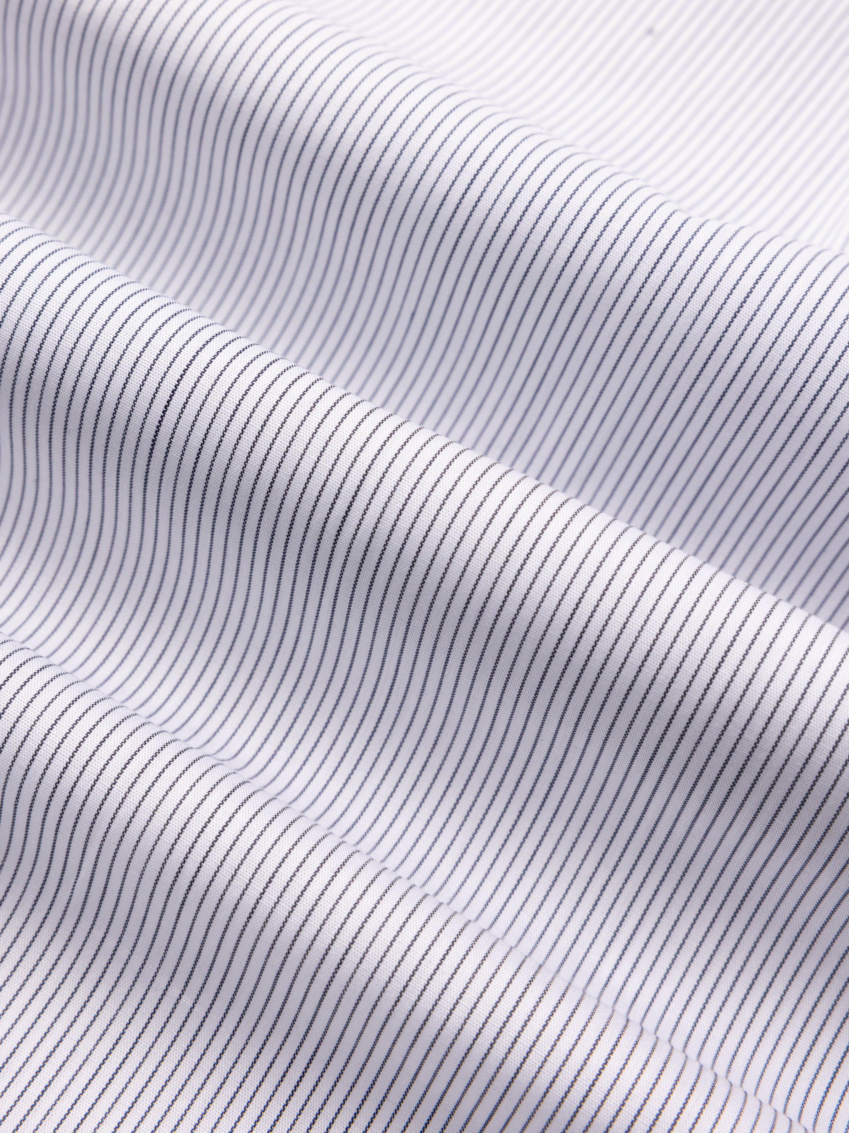 Close-up of white shirt fabric with thin blue stripes