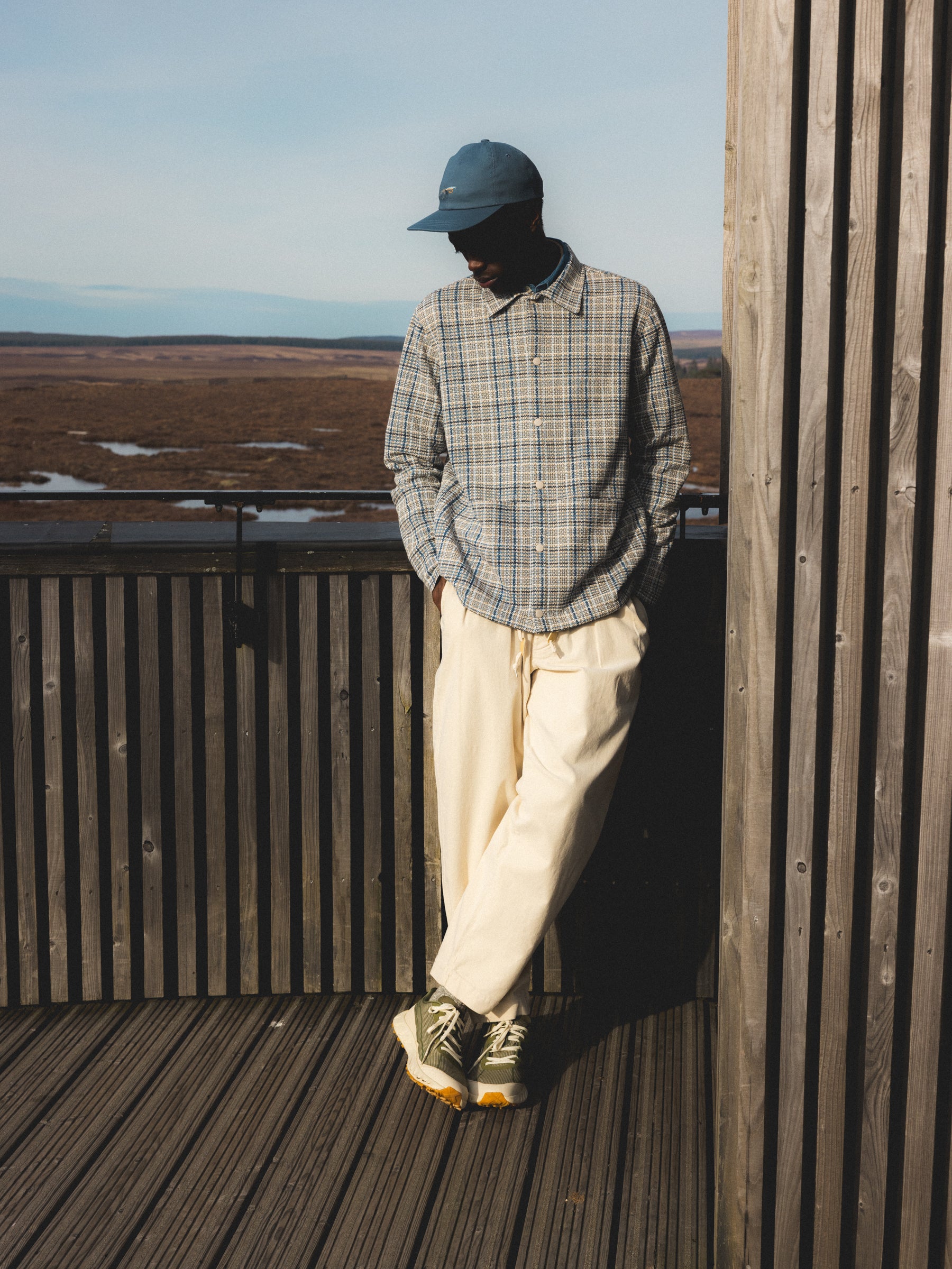 A man wearing cream pants and a blue check jacket from menswear brand KESTIN