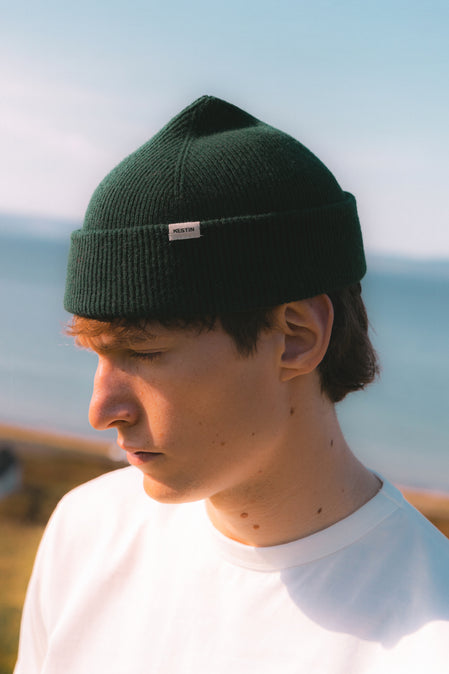 A man wearing a green knitted beanie in Scotland.
