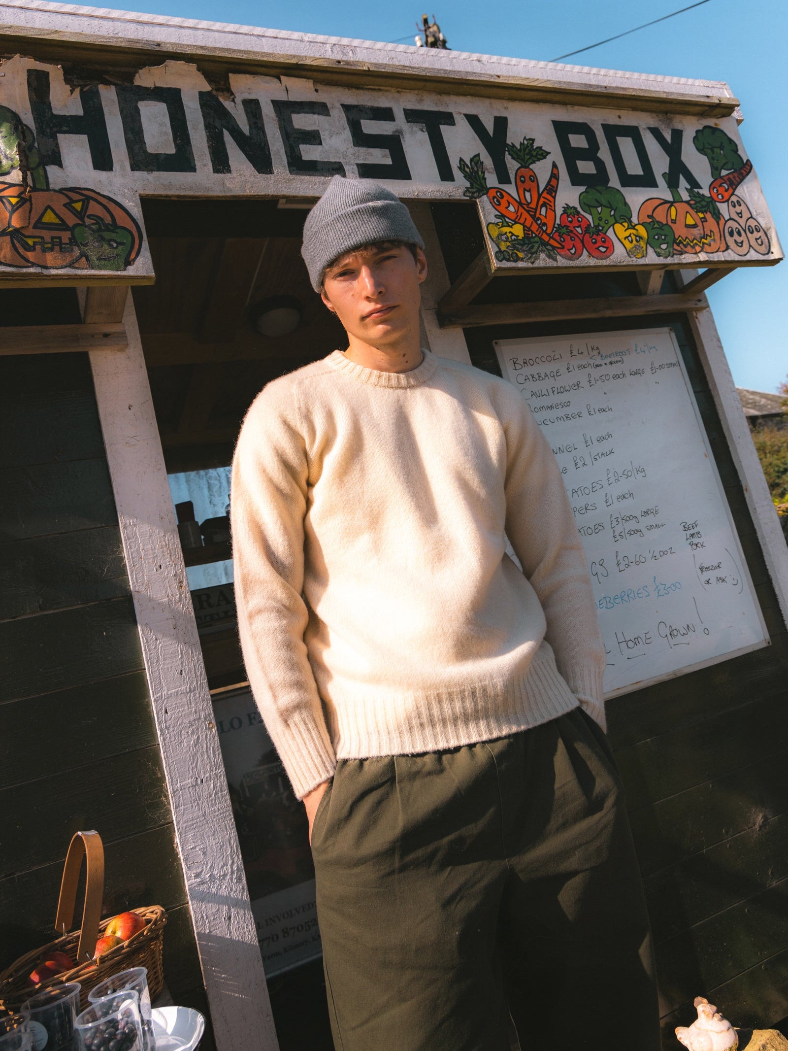 A model stood by an honesty box on the Isle of Arran, wearing a knitted sweater.
